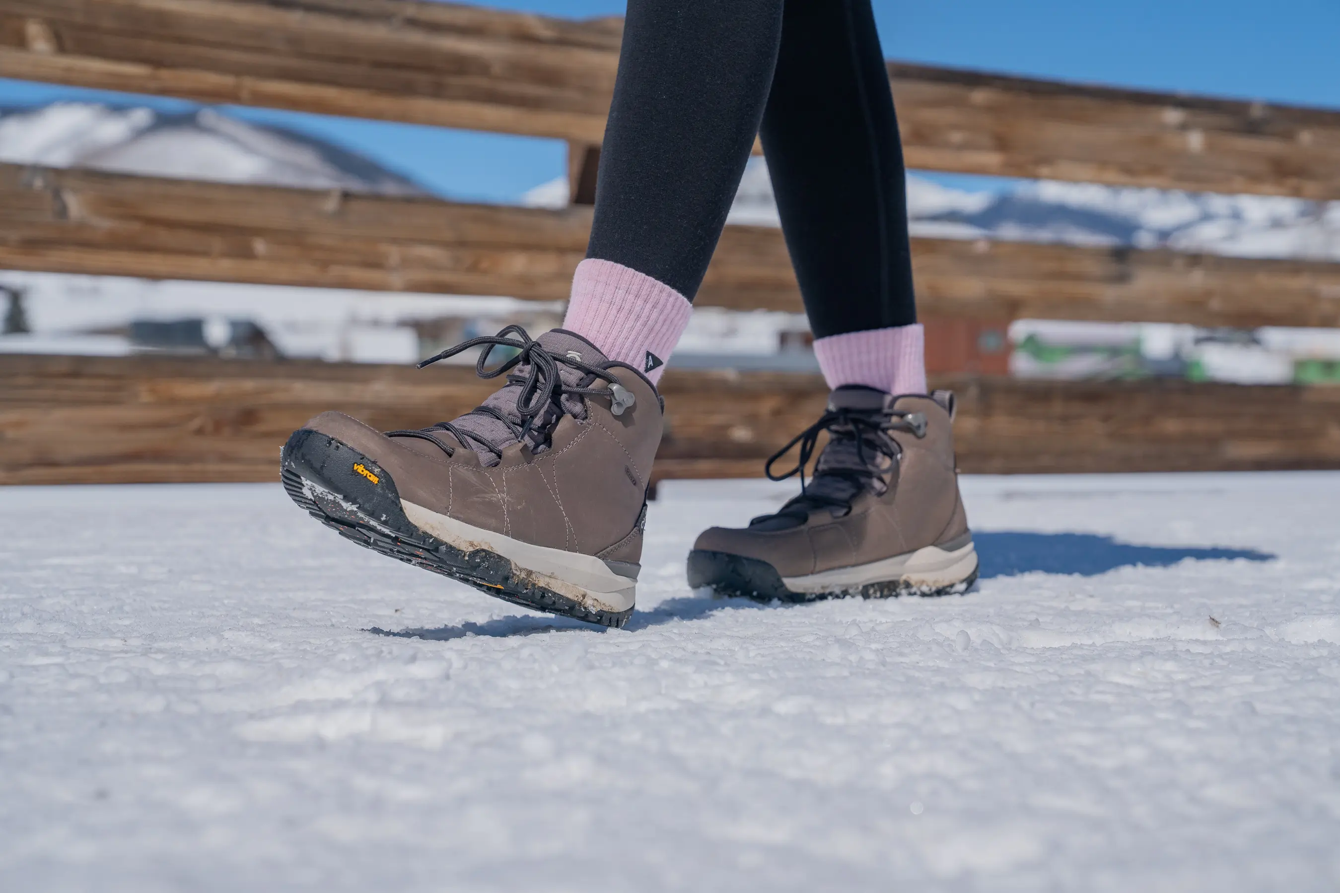 walking across a snowy bridge while wearing women's winter boots 