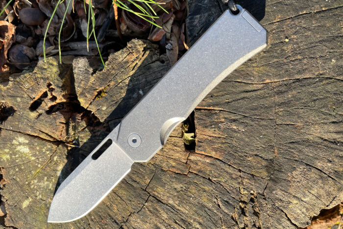 Big Idea Designs Ti Knife open on a stump