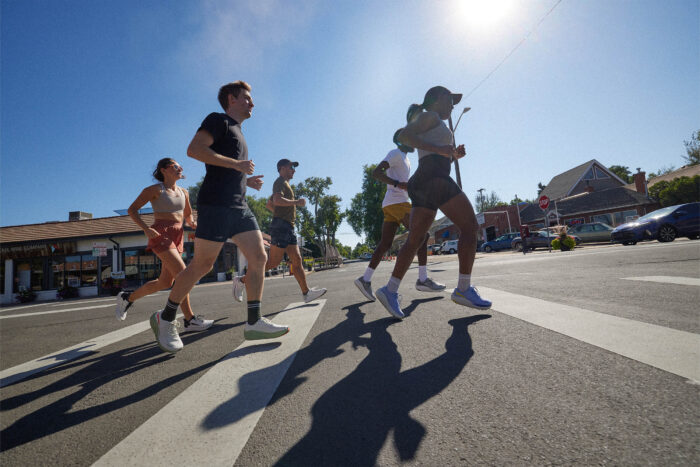 A group of people wearing Altra VIA Olympus 2 shoes runs across a crosswalk
