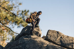 a man scrambles over a rock