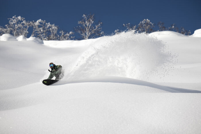 snowboarder kicking up powder snow in Japan