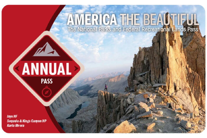 an image of an america the beautiful pass. The pass features a photo of a hiker standing on an overlook