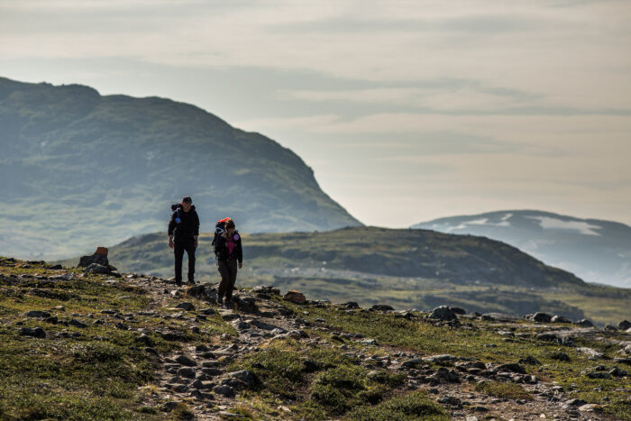 two hikers walk along a trail in Sweden