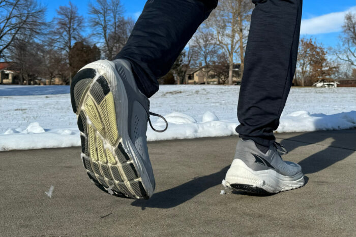 a tester taking a step in the Altra Via Olympus 2 on sidewalk pavement