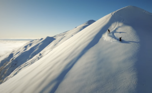 two Mountain Hardwear splitboard athletes descending a pillowy mountain in the Japanese Alps