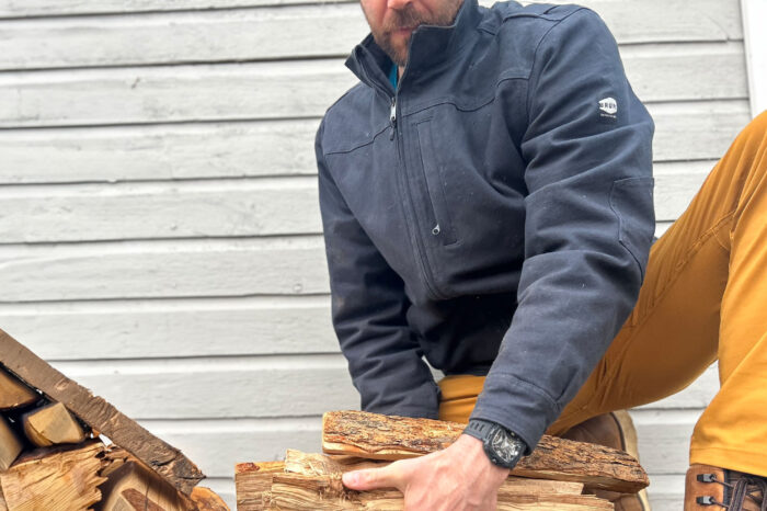 man picking up firewood in brunt work jacket