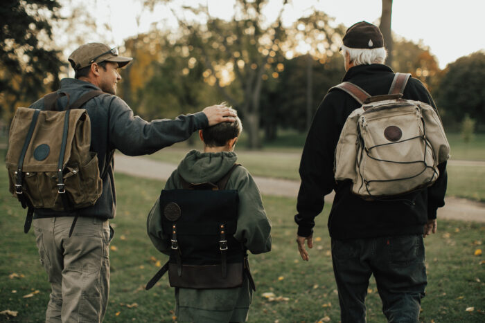 three generations of men wear Duluth packs