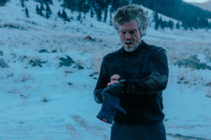 a man looks at his watch while running in the cold