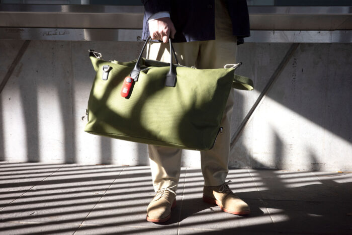 The Knog smart travel luggage tag on a green duffel 