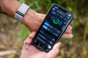 whoop 4.0 health monitor on wrist next to phone app