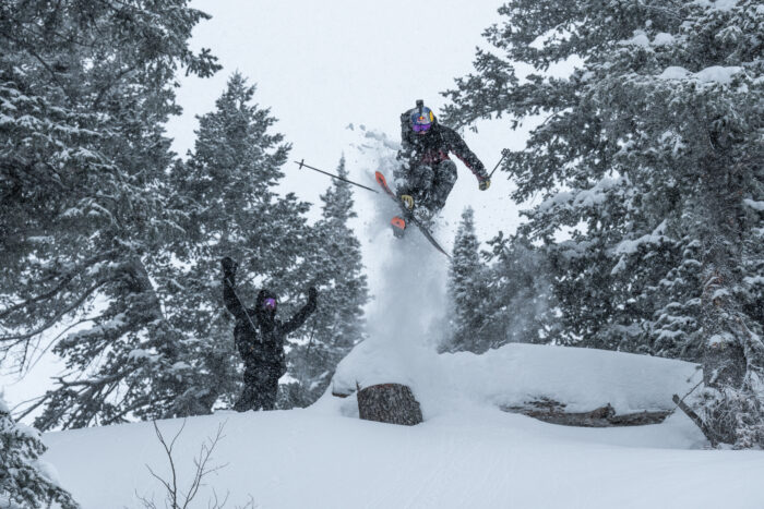 A skier jumps over a cliff at Powder Mountain