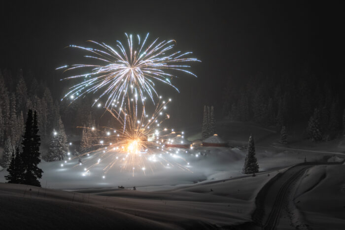 Fireworks over a snowy forest