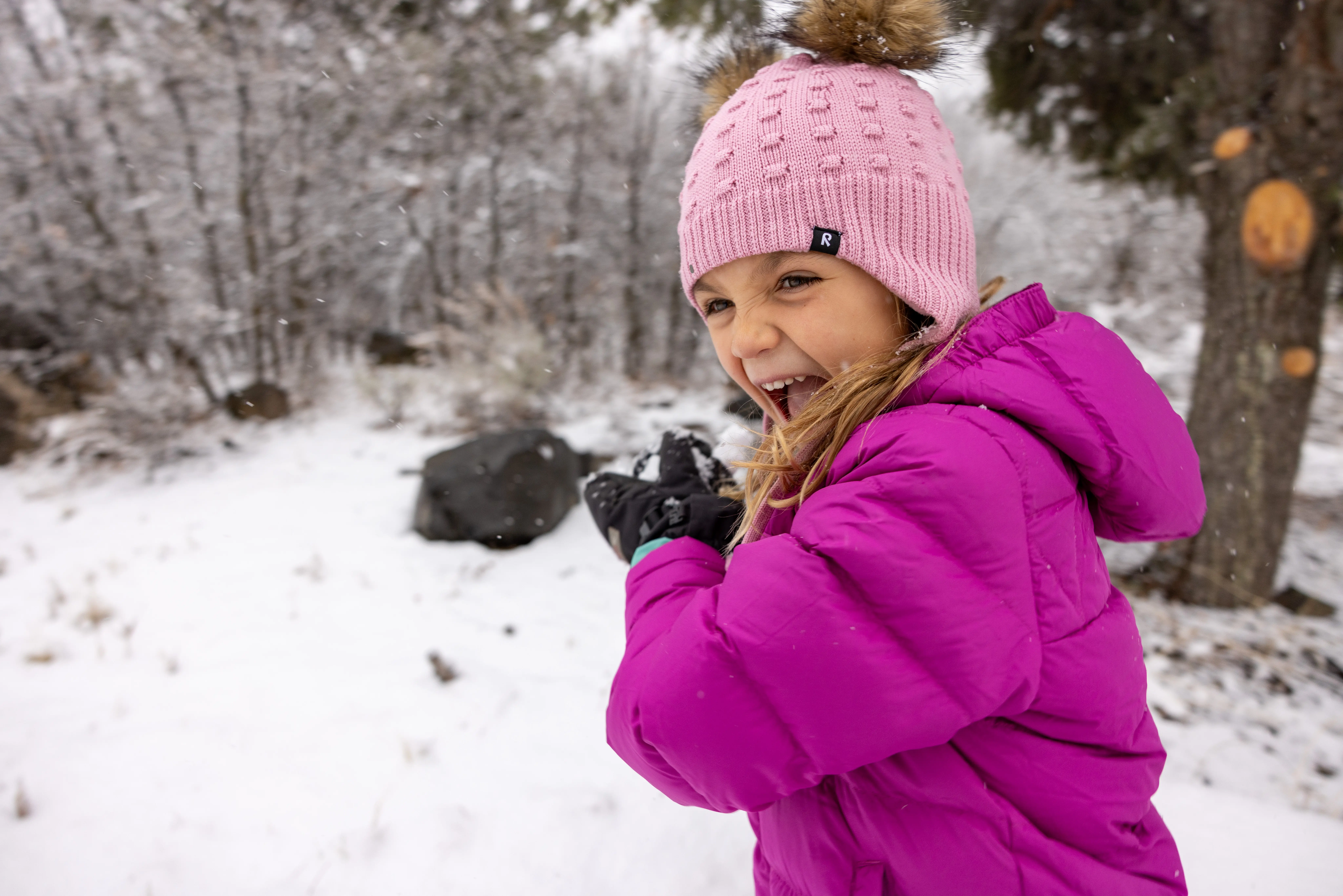little girl throwing a snowball