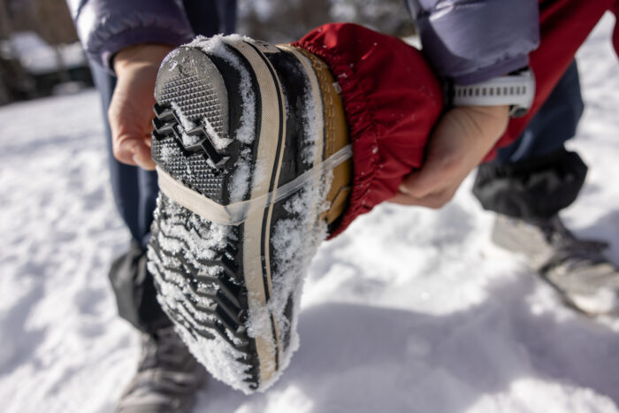 the underside of snow boots with a strap that holds pant legs down for kids 