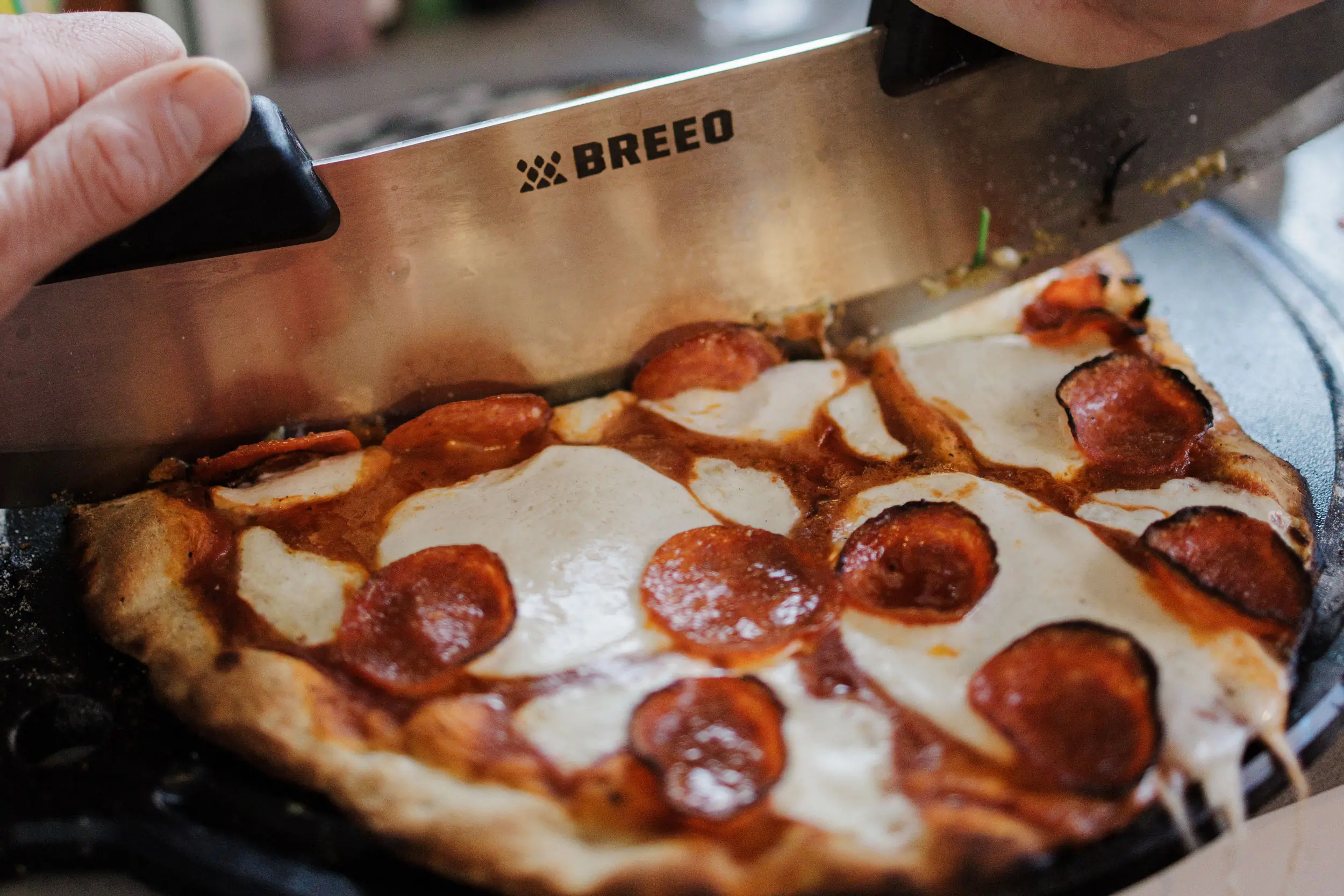 Breeo pizza rocker cutting pepperoni pizza
