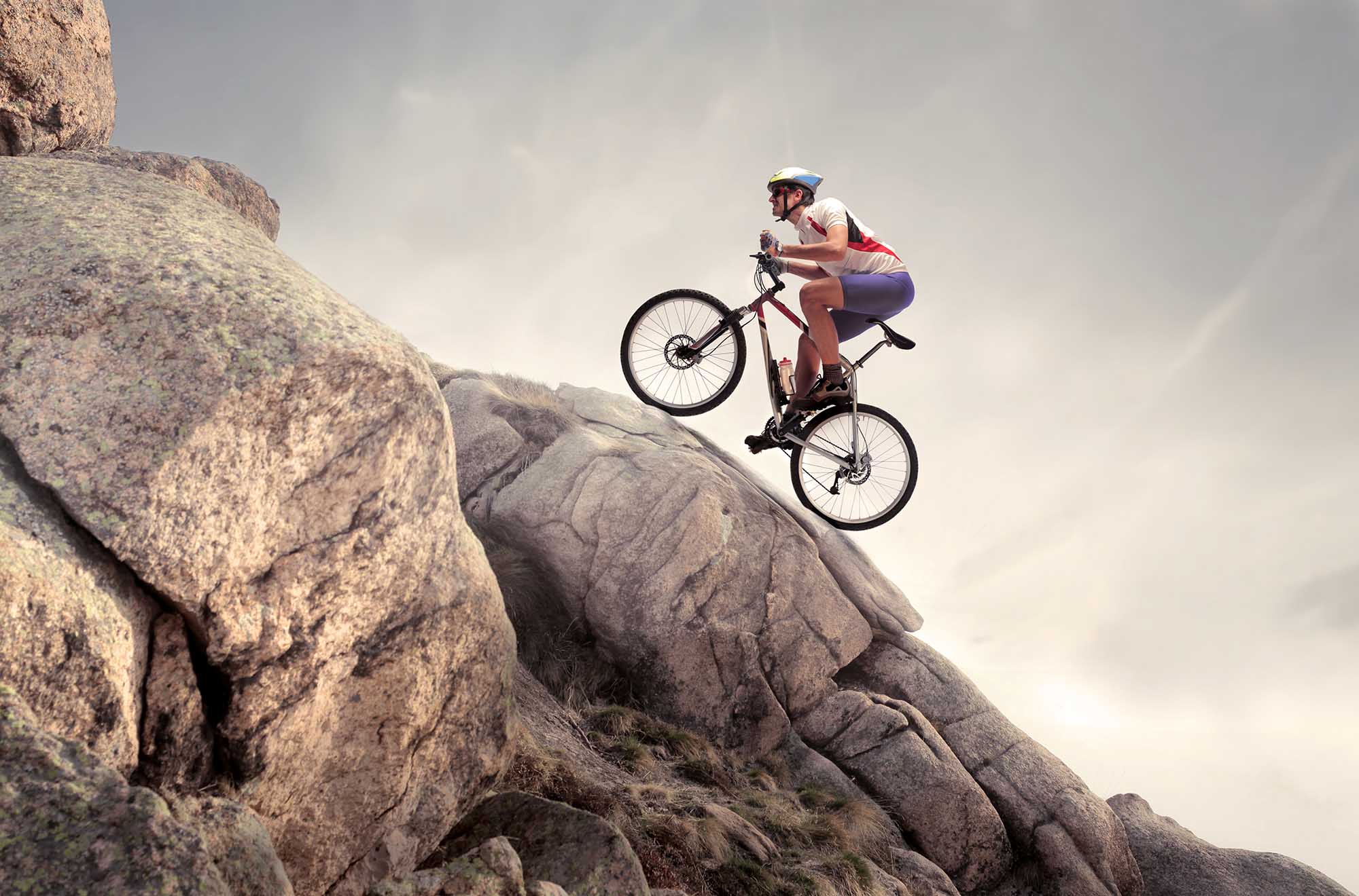 Cyclist,Climbing,On,A,Rock