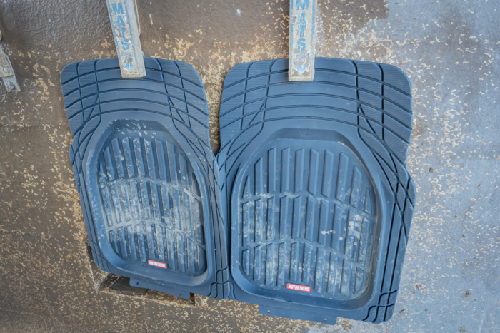 two car floor mats hanging at car wash 