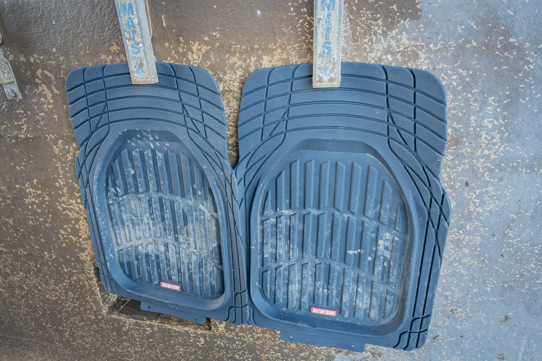 two car floor mats hanging at car wash 
