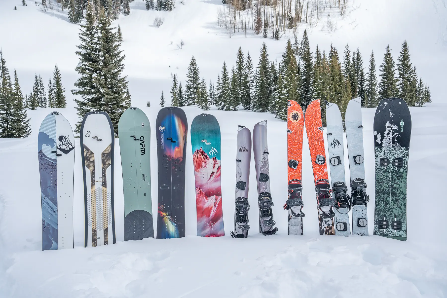 a lineup of splitboards standing in the snow