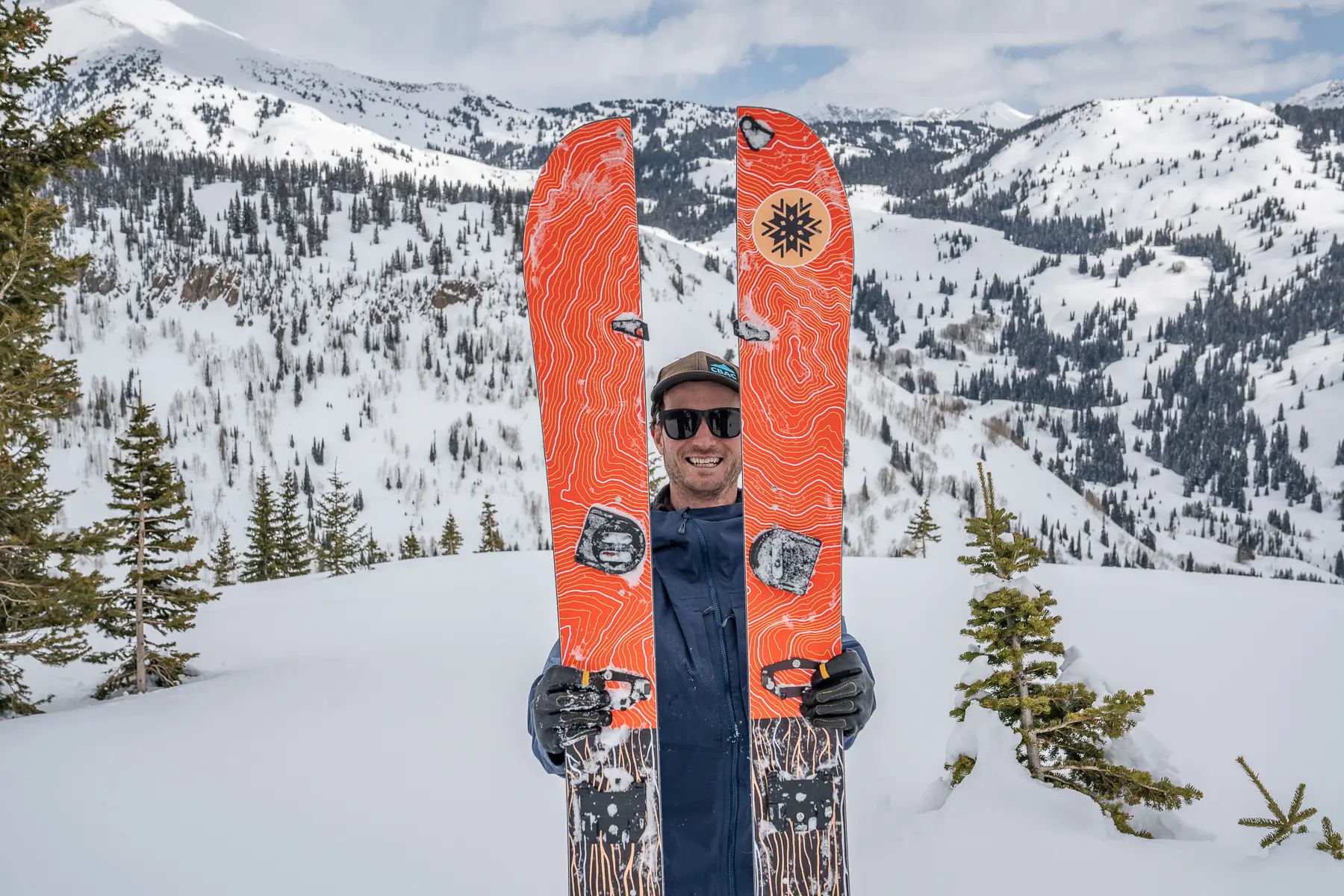 man holding two splitboard skis