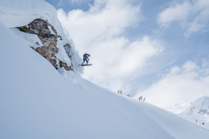 splitboarder hitting a cliff drop 