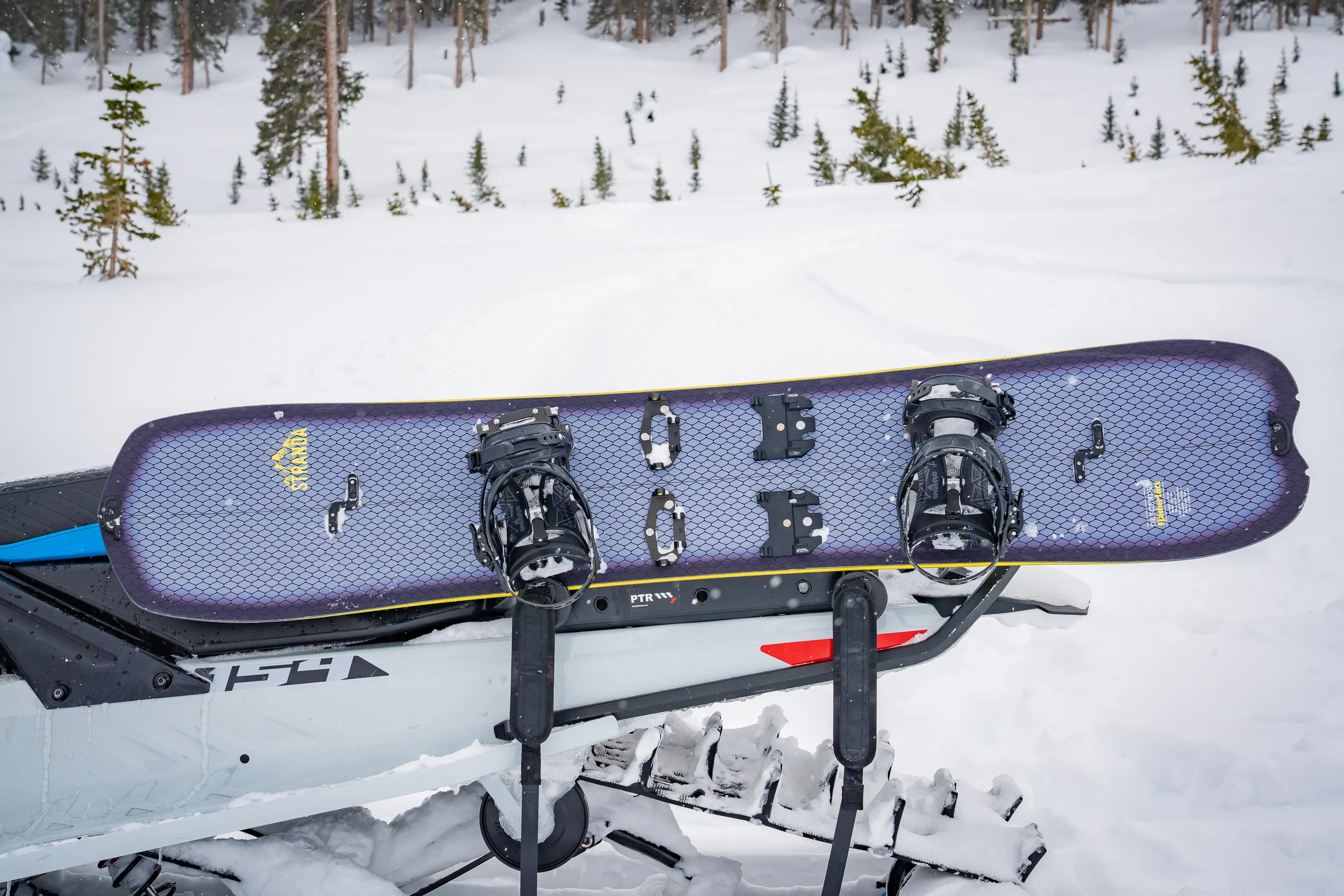 splitboard sitting in rack on snowmobile