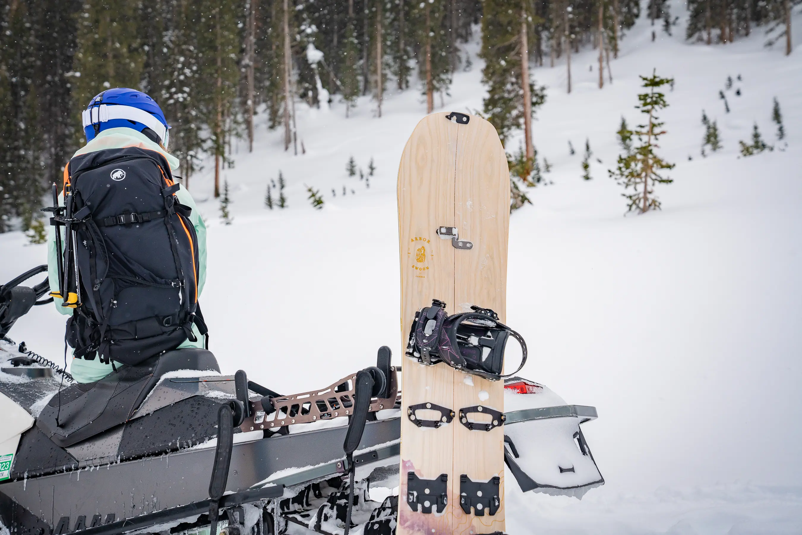 splitboard standing next to snowmobile