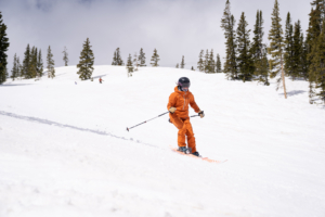 A skier on a rolling blue-rated groomed ski run