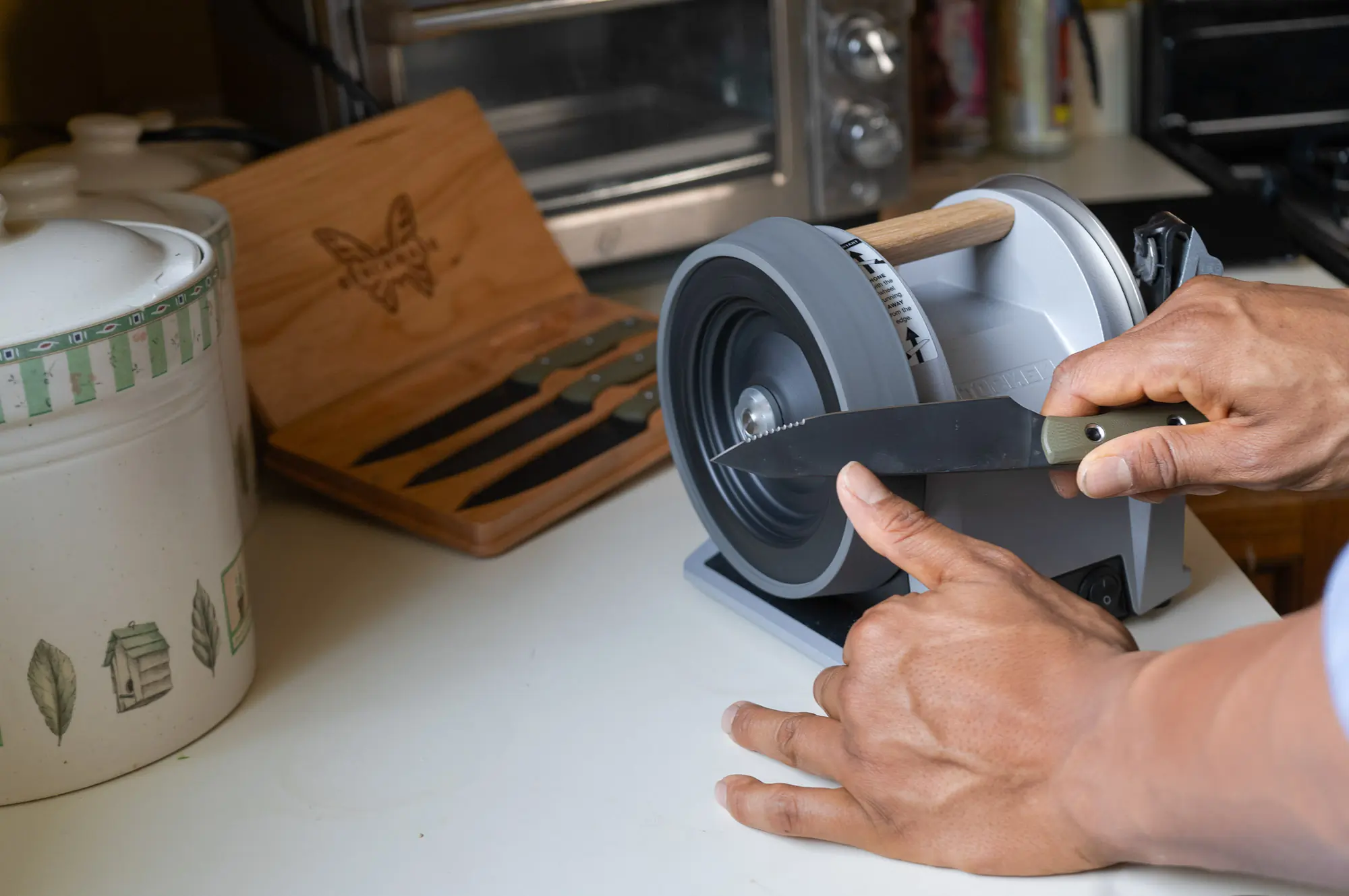 the author sharpening a benchmade kitchen knife on a countertop tormek electric sharpener