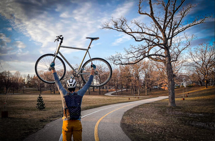 man holding bike overhead