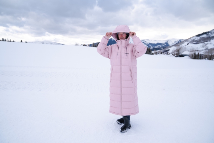 woman standing outside on snowy ground while wearing the Pike Lake II Jacket Hood