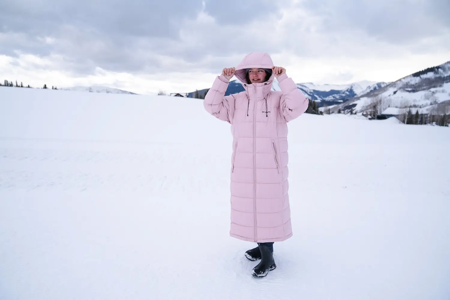 woman standing outside on snowy ground while wearing the Pike Lake II Jacket Hood