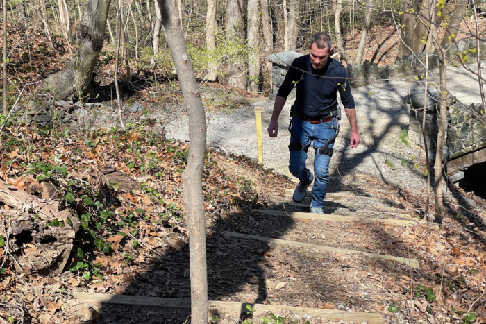 man hiking uphill while wearing adjusting dnsys x1 exoskeleton leg lifter