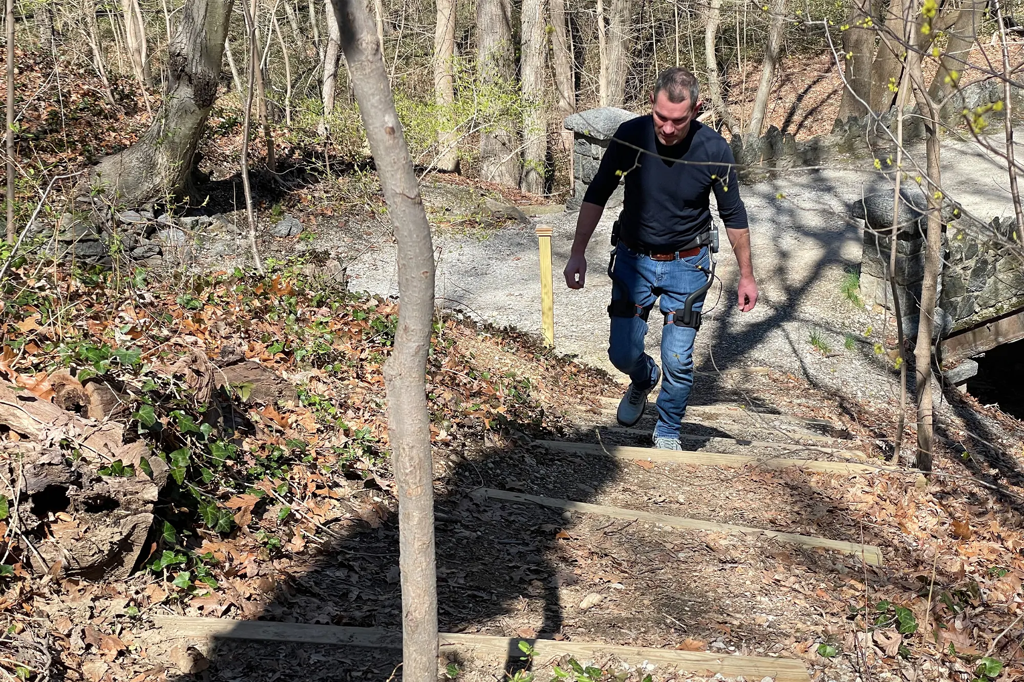 man hiking uphill while wearing adjusting dnsys x1 exoskeleton leg lifter