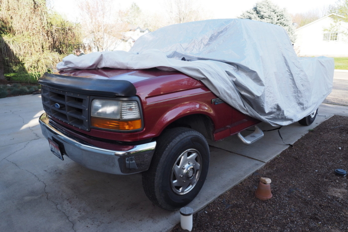 Car cover on top of a red truck