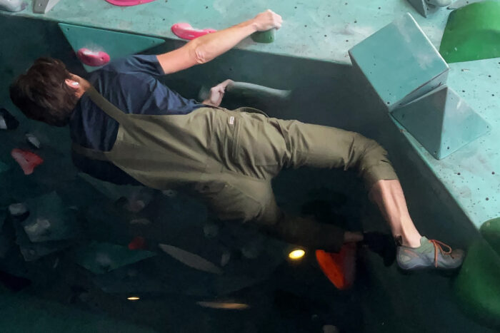 man bouldering in livsn overalls