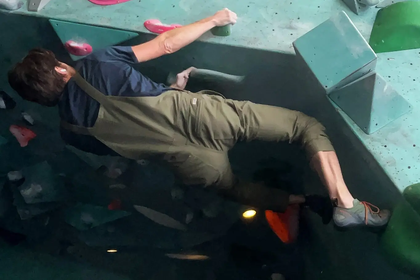 man bouldering in livsn overalls
