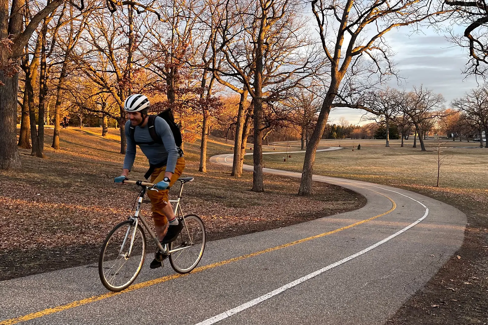 biker riding cheap fixie on s curve up hill