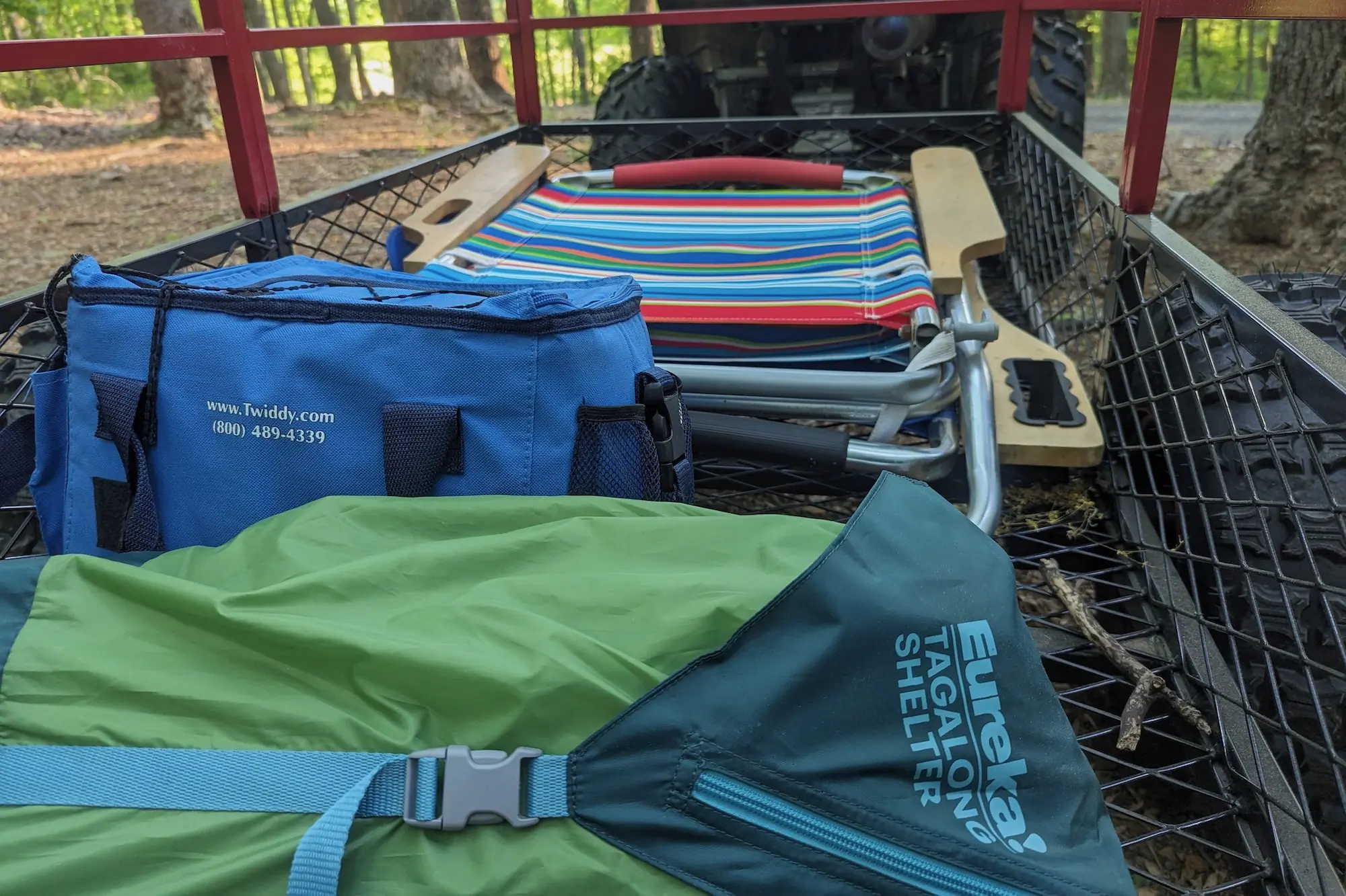 The Eureka Tagalong Shelter packed up and sitting in a utility trailer behind an ATV