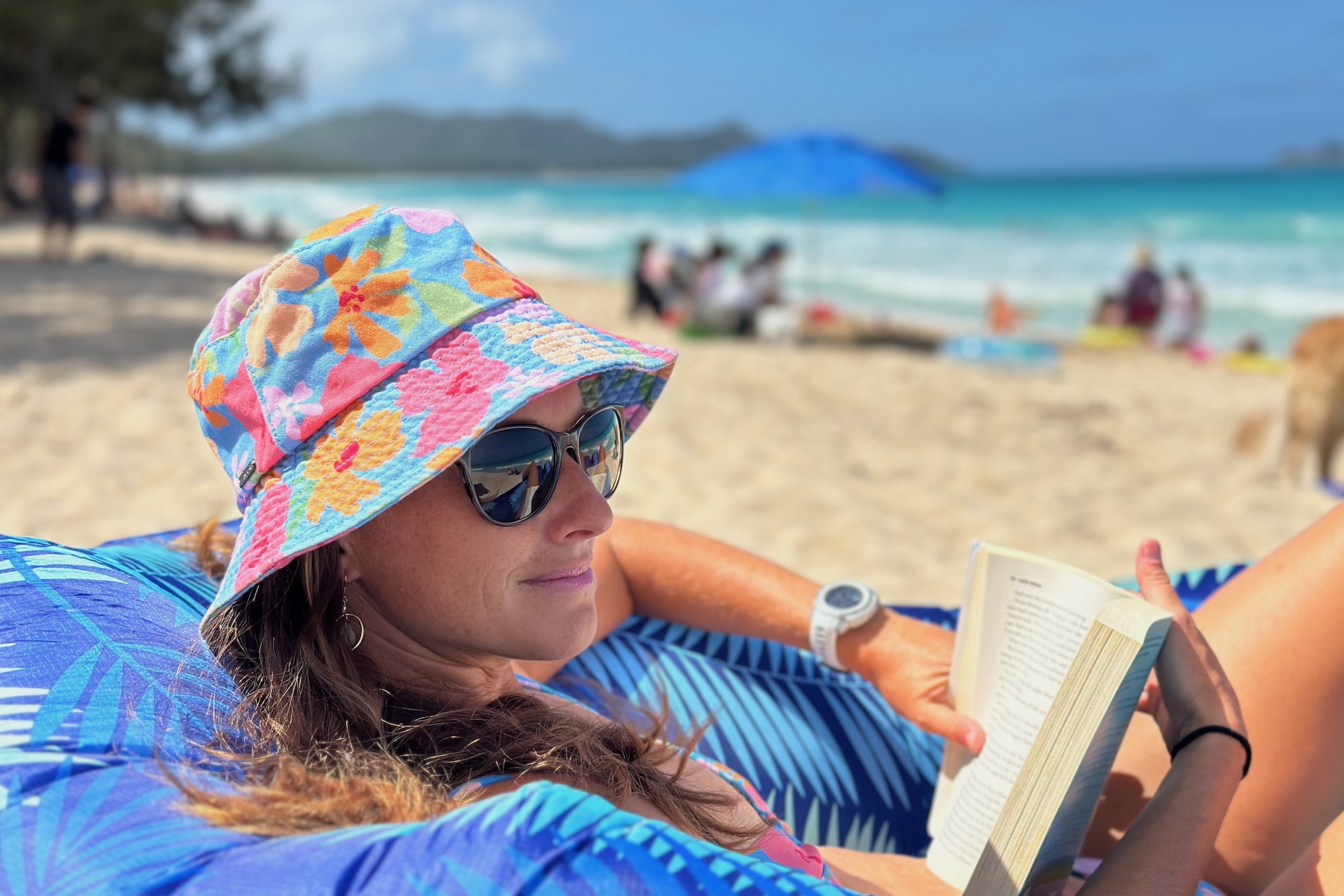 Wearing the Costa Del Mar Catherine women's sunglasses while reading a book and lounging at the beach