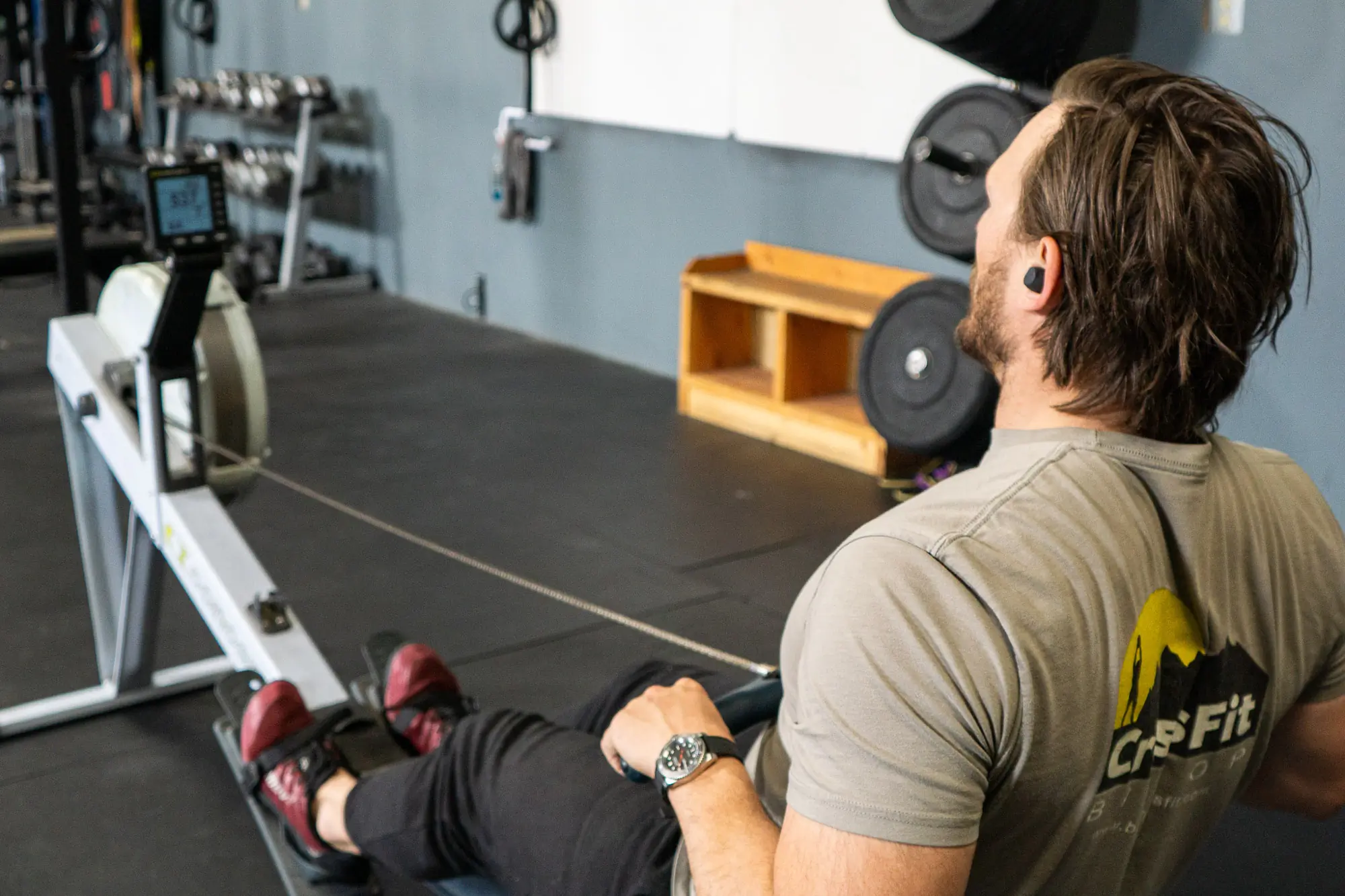The author on a rowing machine wearing the Elite 8 Active earbuds