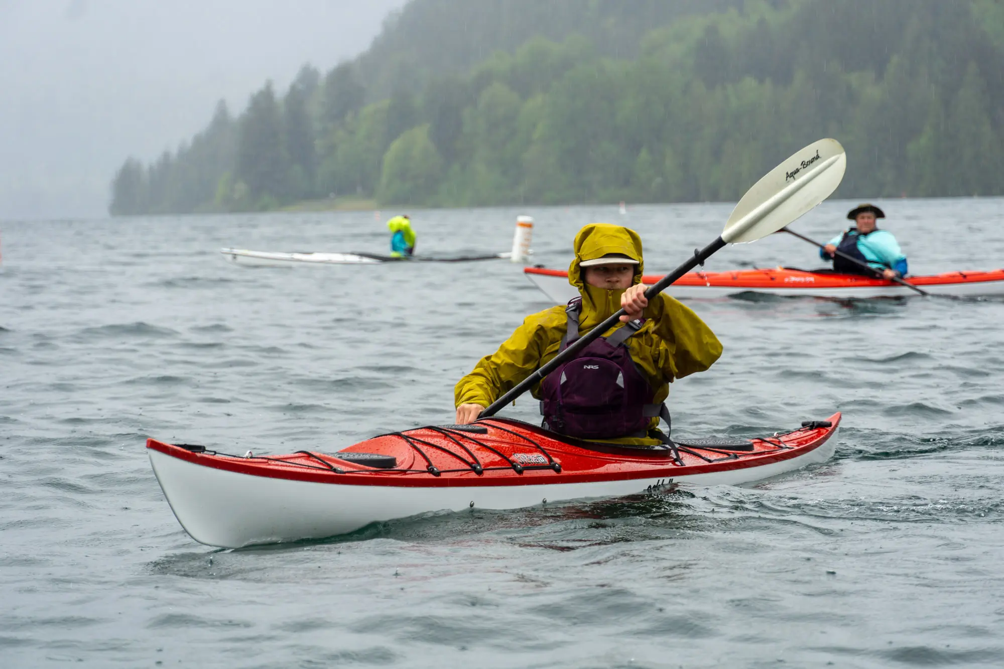 a kayaker paddles the Eddyline Sitka in a Canadian lake with other paddlers