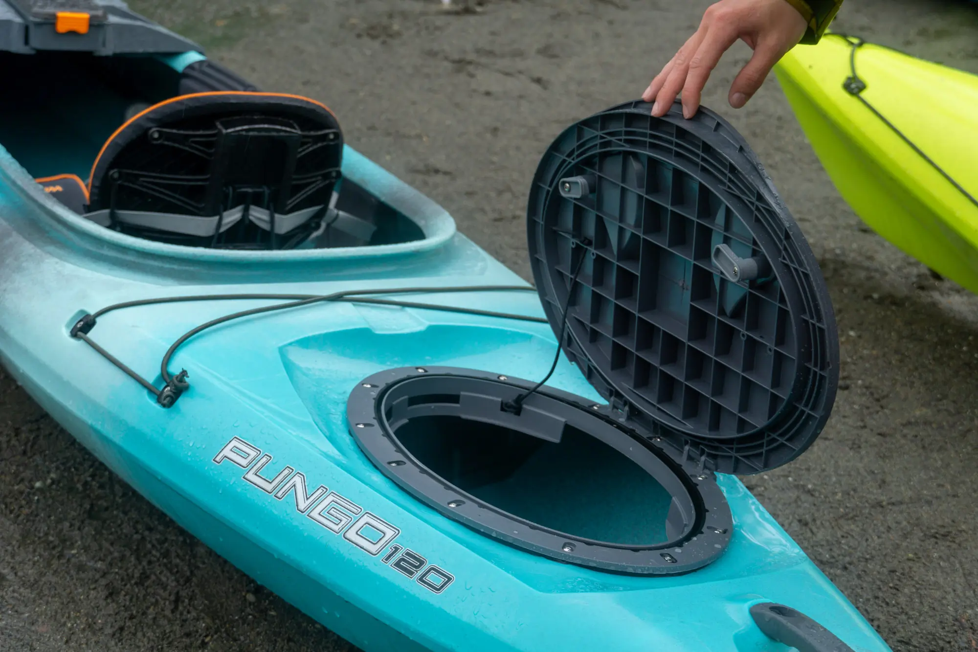 a paddler holds open the rear storage hatch on the wilderness systems pungo