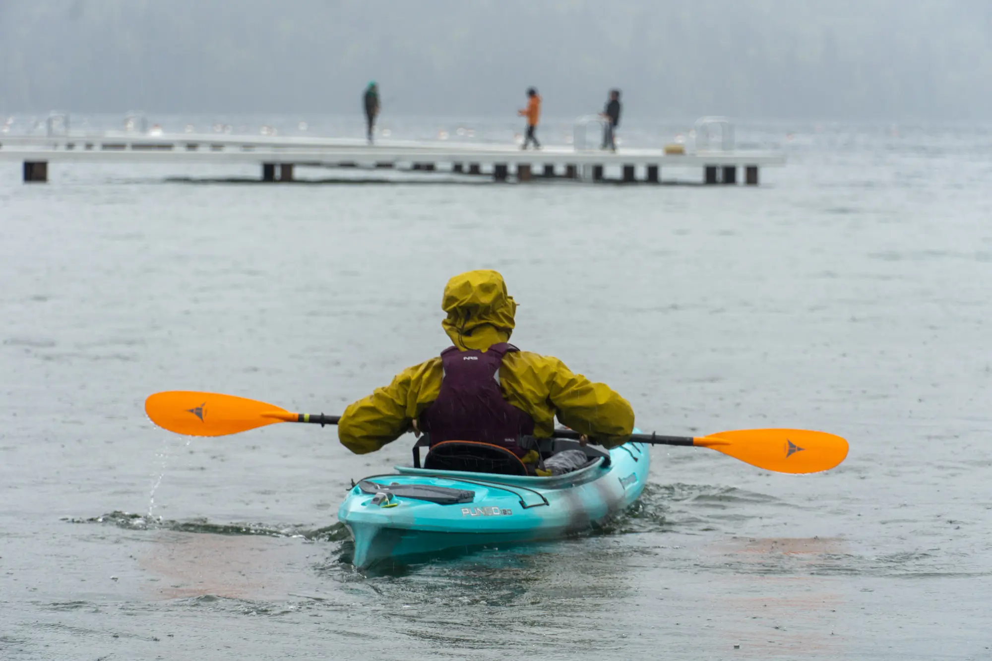 a rear view of a kayaker in the rain