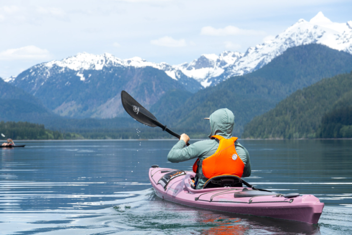 a paddler in the North Cascades paddles a touring kayak on an overnight trip