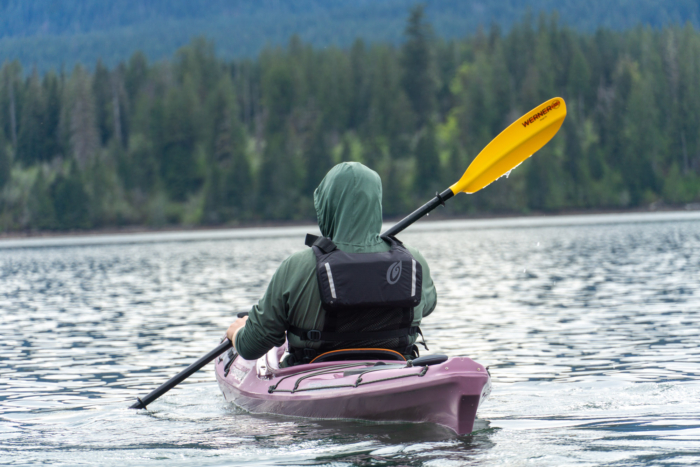 A kayaker in a purple touring kayak paddles a Werner Skagit FG paddle