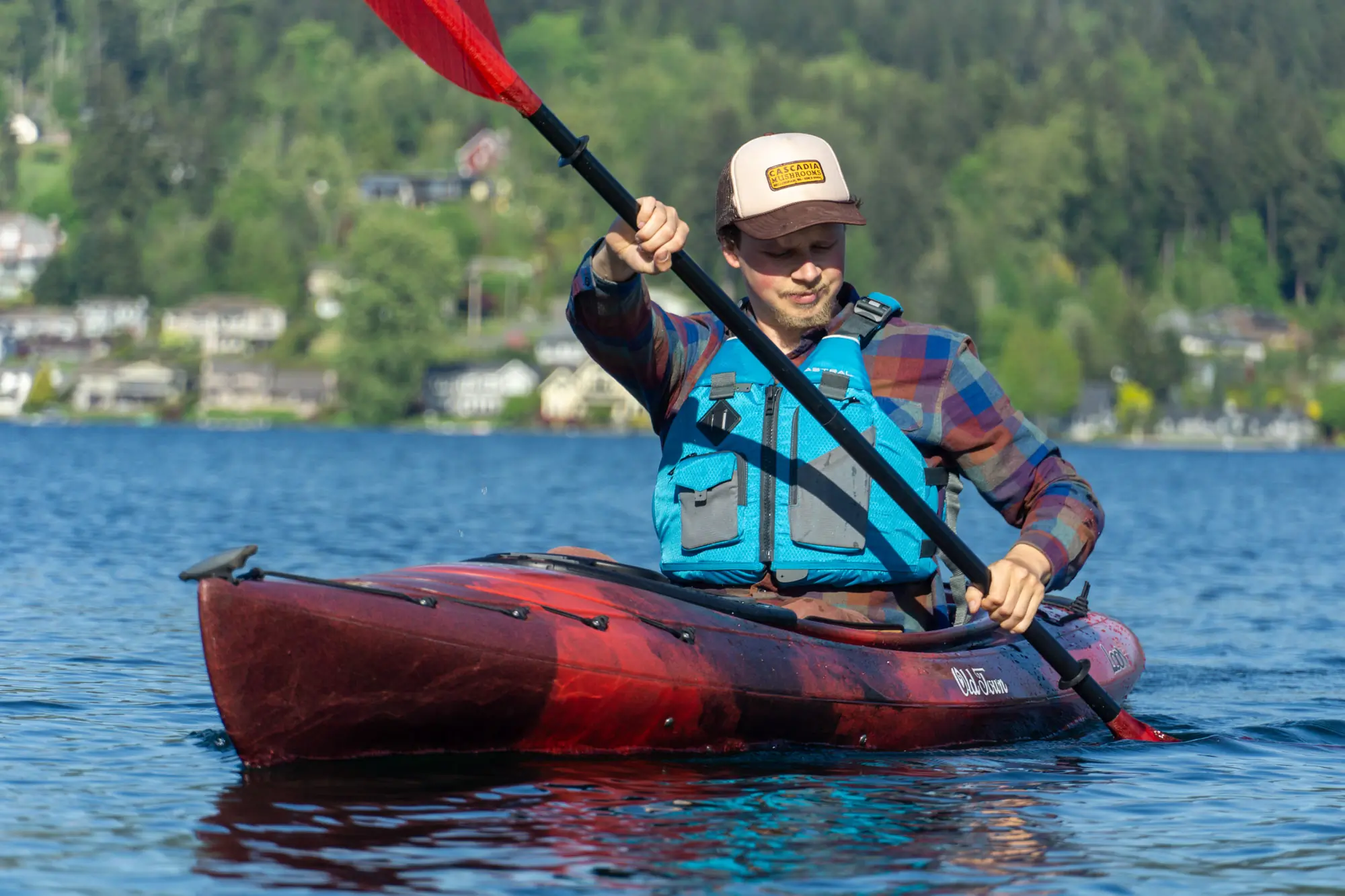 A kayaker executes a deep, high-angle paddle stroke 