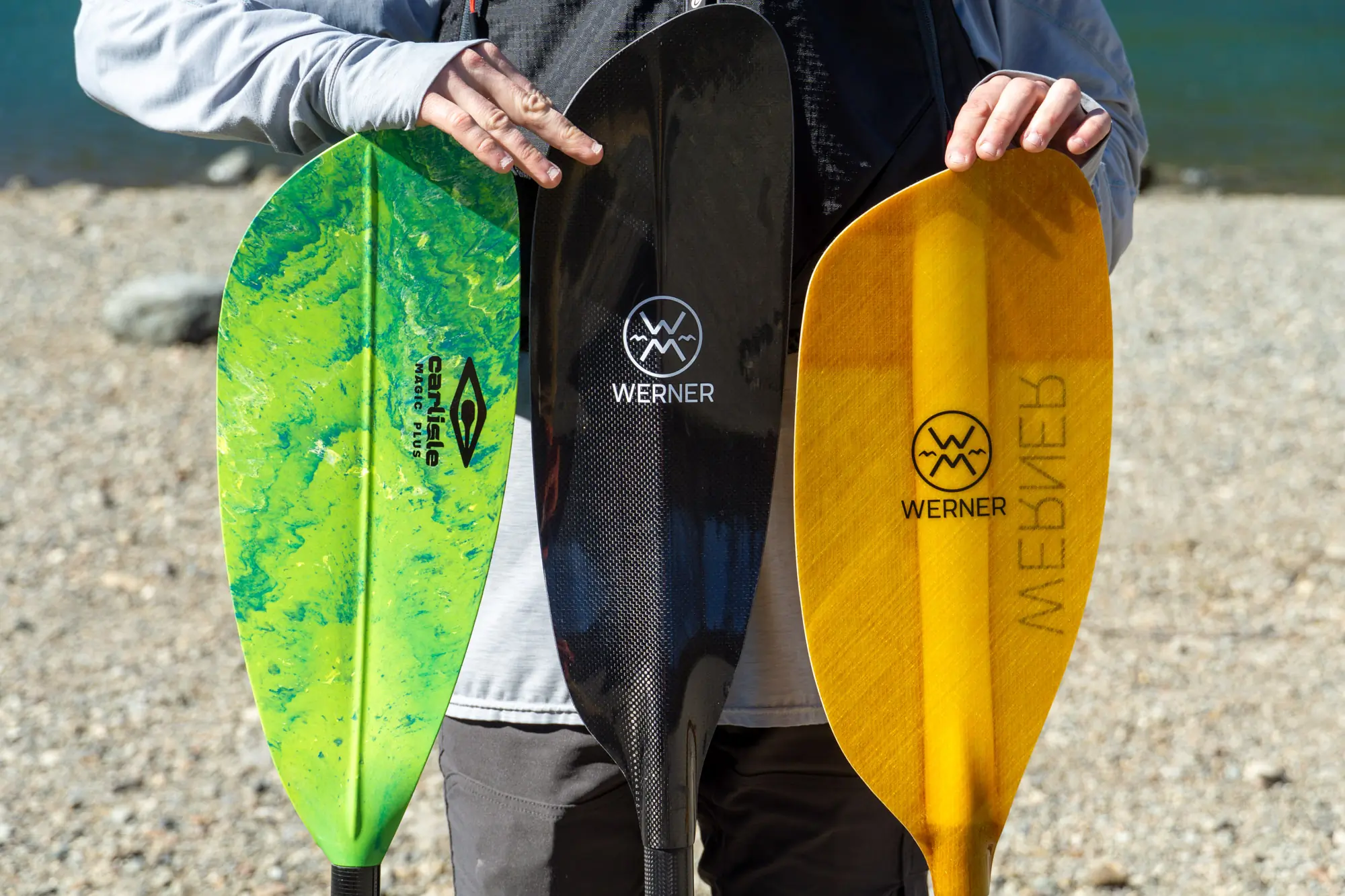 Three kayak paddles in a row show the different in blade size and shape
