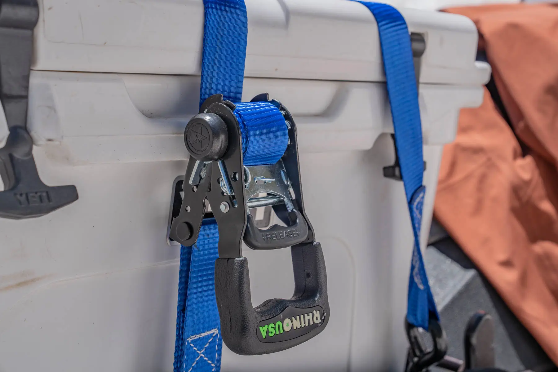 ratchet strap tightened around a hard cooler 