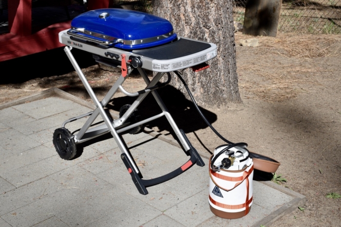 full view of the Ignik Gas Growler in action, fueling the Weber Traveler Gas Grill